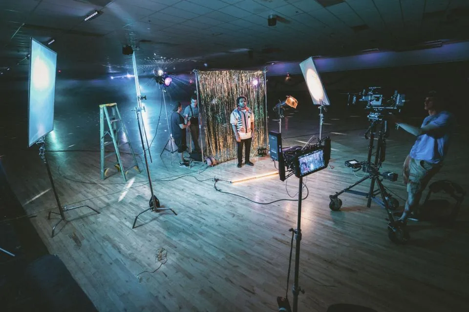 A video set with lights, cameras and a small crew at work