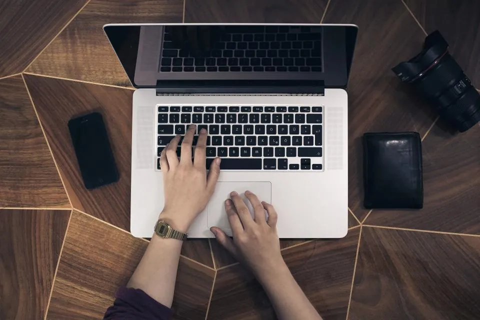 Hands typing on a laptop, seen from above